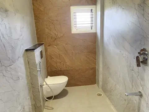 Attached bathroom with brown accent wall and shower, Villa 1