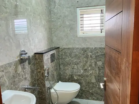 Attached bathroom with stone-look tiles and wall-hung toilet, Villa 1