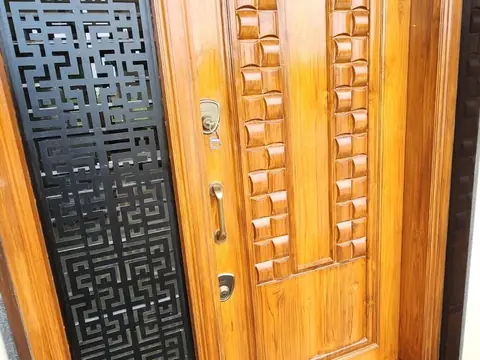 Teak main door with carved panels and black jaali side panel, Villa 1