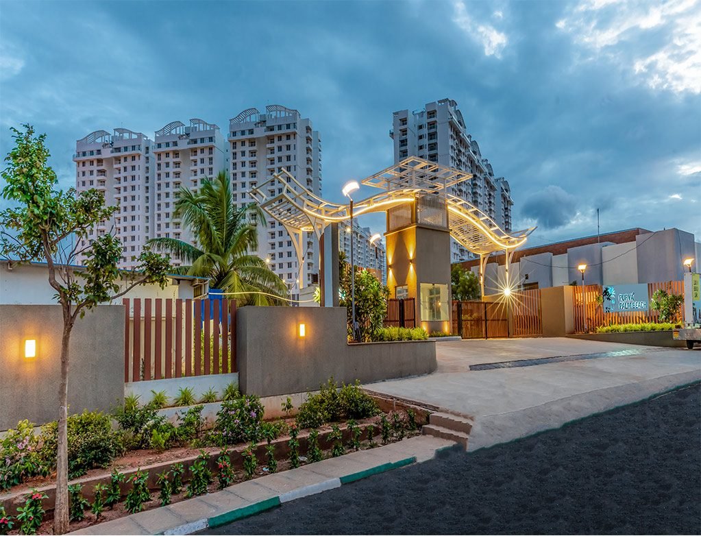 Entrance gateway of Purva Palm Beach on Hennur Road at dusk with the towers behind
